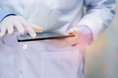 Midsection of person using mobile phone