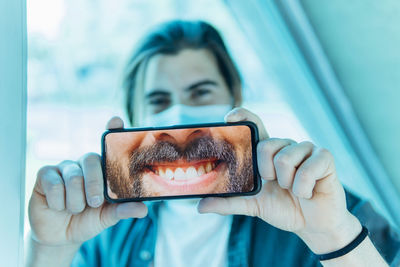 Portrait of man holding mobile phone