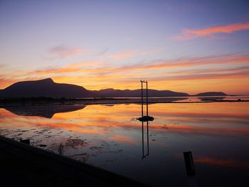 Scenic view of lake against orange sky