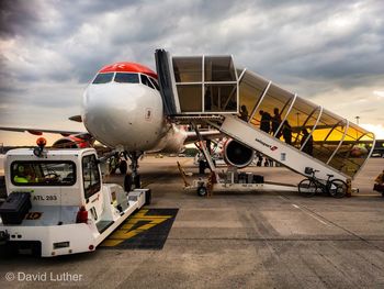 Airplane on airport runway against sky