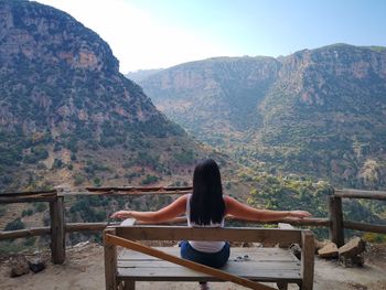 Woman sitting on mountain looking at mountains