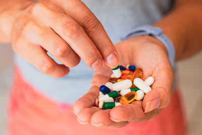 Midsection of man holding pills