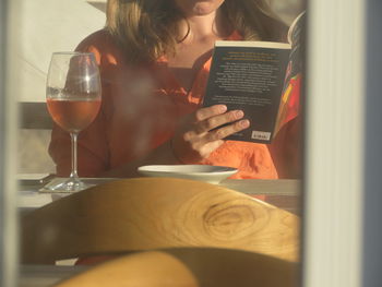 Midsection of woman sitting on table