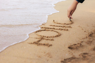 Low section of child on sand at beach