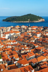 High angle view of townscape by sea against clear sky