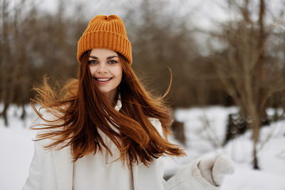 Portrait of young woman standing on snow