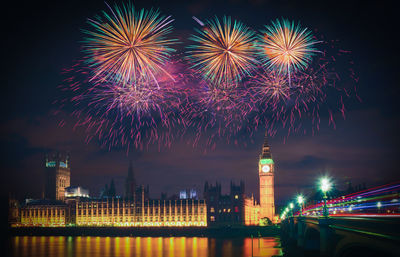 Firework display over city lit up at night