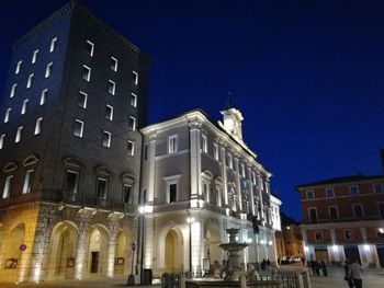 Low angle view of illuminated building against sky at night