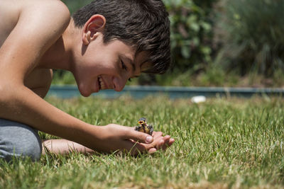 Side view of young woman playing on grassy field