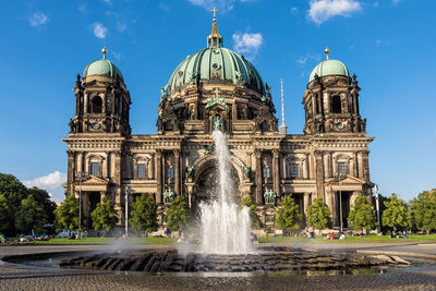 Fountain in city against sky