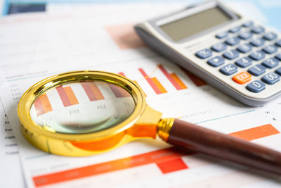 High angle view of magnifying glass on paper