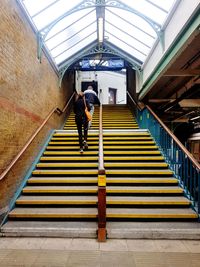 Rear view of man walking on staircase