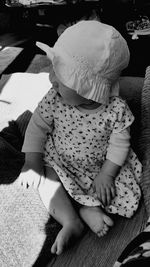 High angle view of baby girl sitting on bed at home