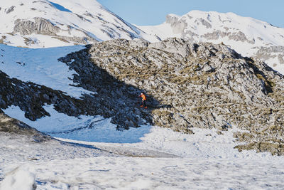 Unknown man practices cross-country skiing in snowy mountains
