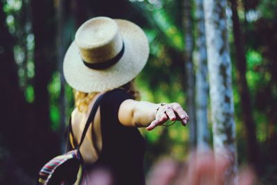 Rear view of woman wearing hat at forest