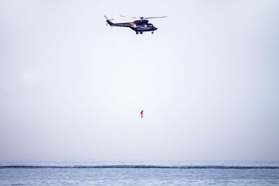 Low angle view of paragliding over sea against clear sky