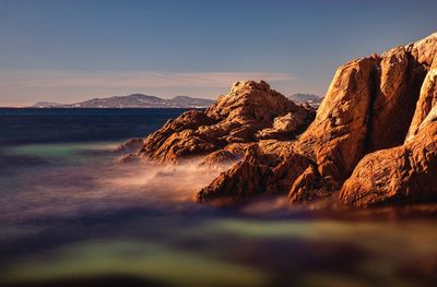 Scenic view of sea and mountains against sky during sunset