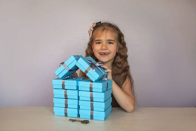 Portrait of smiling young woman standing by toy on table