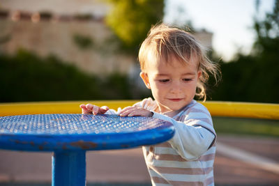 Close-up of boy holding play equipment at playground