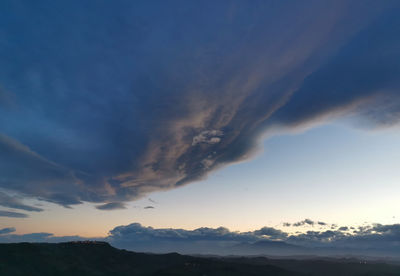 Low angle view of silhouette mountain against dramatic sky