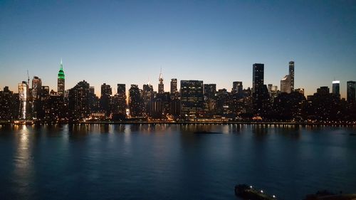 View of city lit up against clear sky