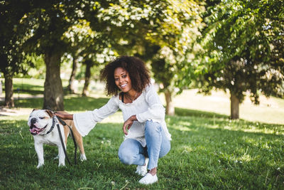 Full length of woman with dog on grass