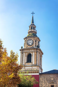 Low angle view of san francisco church clock tower against blue sky