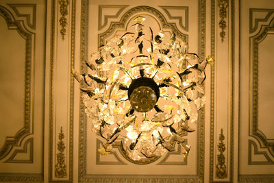 Directly below shot of illuminated chandelier hanging on ceiling at home