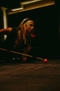 Young woman playing pool