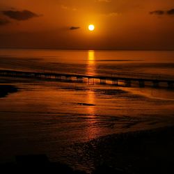 Scenic view of sea against orange sky