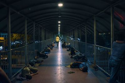 People walking on illuminated bridge in city