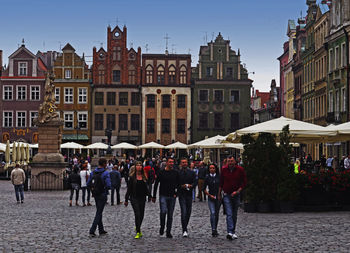 People on street in city against sky