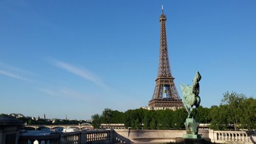 Statue of tower in city against blue sky