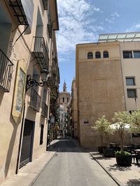 Street amidst buildings in town against sky