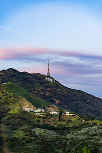 Scenic view of building by mountains against sky