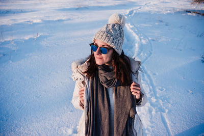 Young woman standing on snow covered landscape