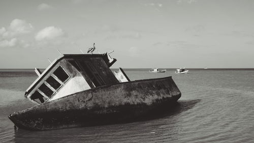 Fishing boat on beach against sky