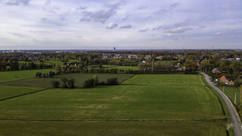 Scenic view of field against sky in city