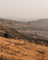 People camping with a beautiful view of mountains and bridge in the distance