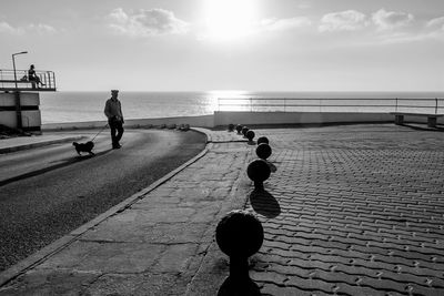 People standing on beach against sky