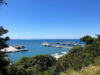 Sailboats in sea against clear blue sky