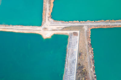 High angle view of swimming pool by sea against blue sky