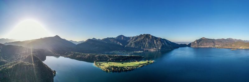 Panoramic view of lake and mountains against clear blue sky