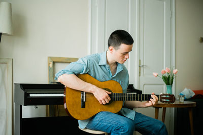 Man playing guitar at home