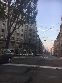 Cars on road in city against clear sky