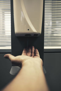 Cropped image of woman using hand sanitizer