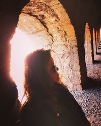 Rear view of woman standing against rock formation