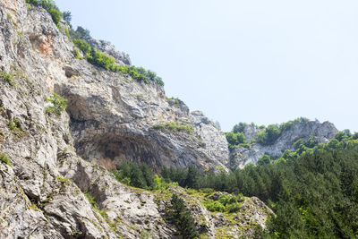 Low angle view of rocks against clear sky