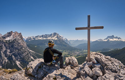 Man looking at mountain against clear sky