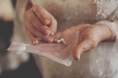 Midsection of bride with earrings during wedding ceremony